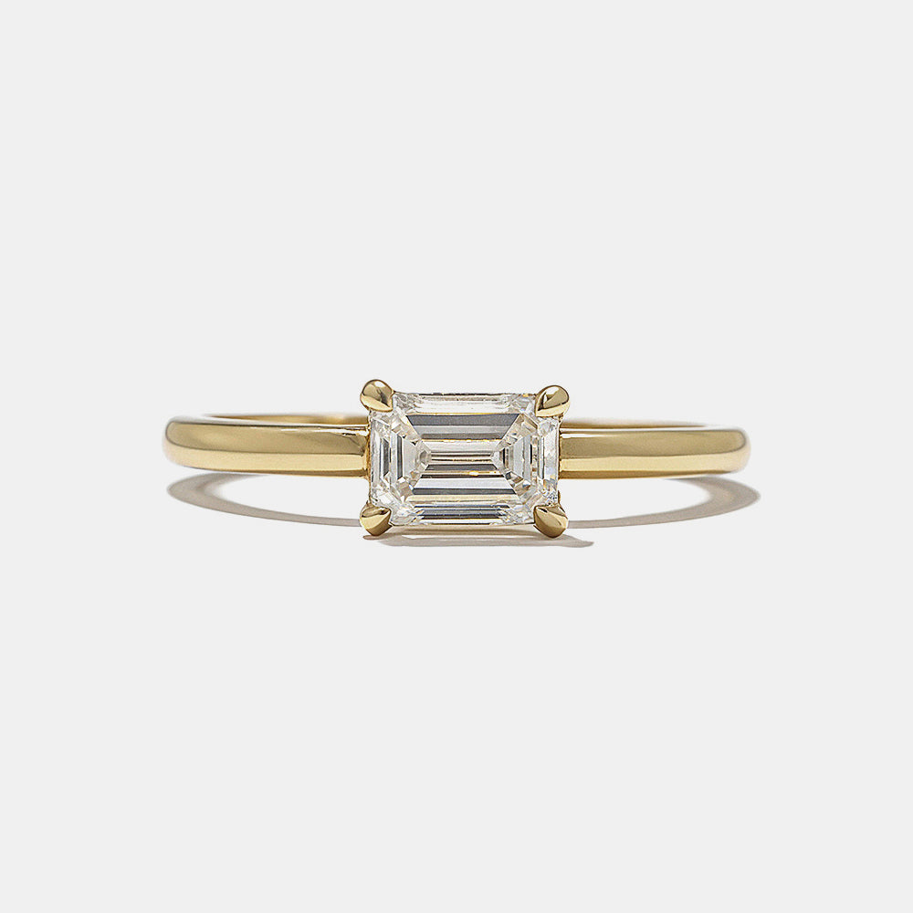 Front view of 0.75 carat east west emerald cut lab grown diamond hidden halo engagement ring with horizontal modern design