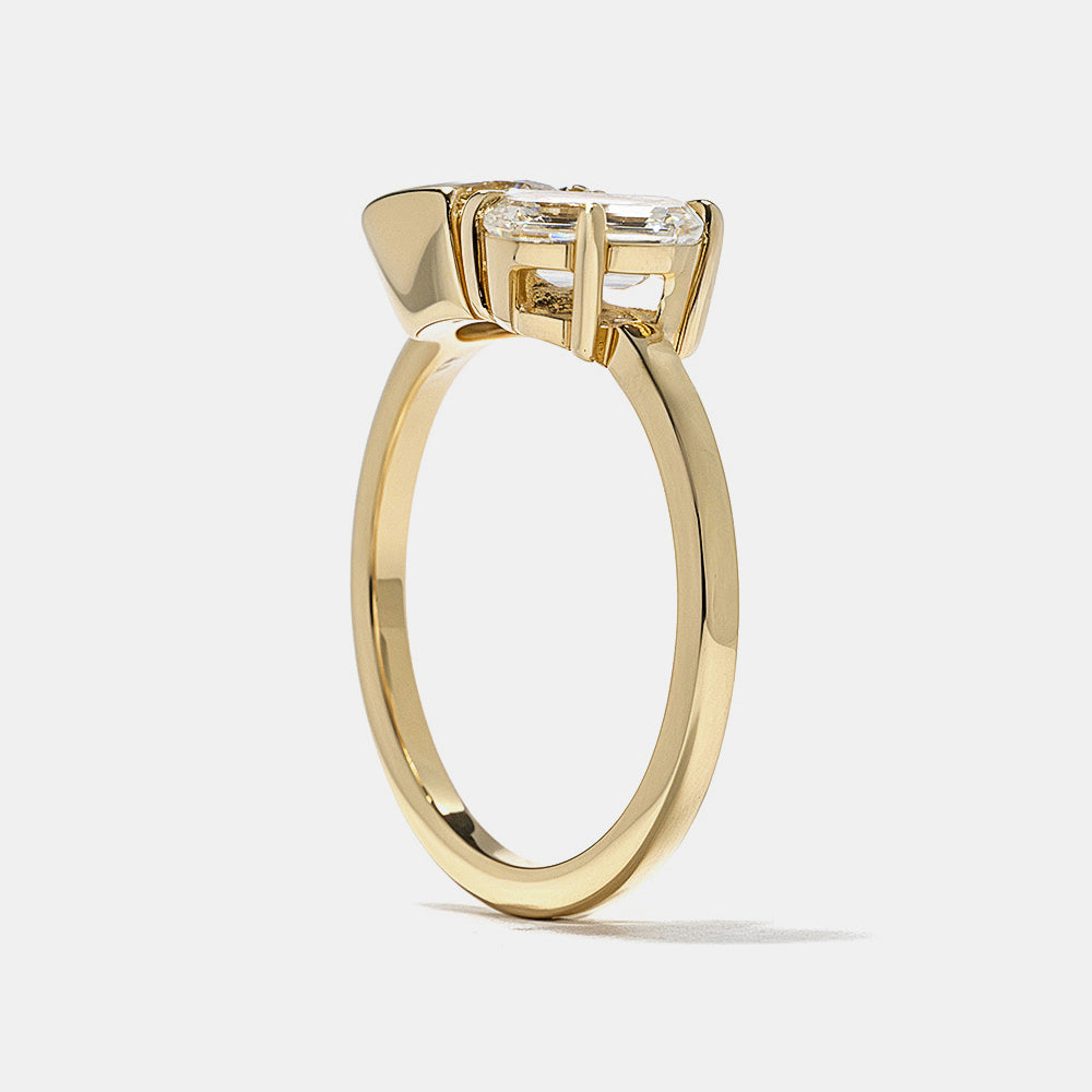 0.8 carat round and emerald cut lab diamond Toi Et Moi engagement ring in polished gold bezel setting