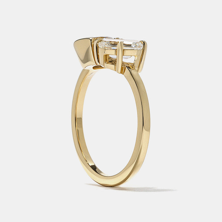 0.8 carat round and emerald cut lab diamond Toi Et Moi engagement ring in polished gold bezel setting