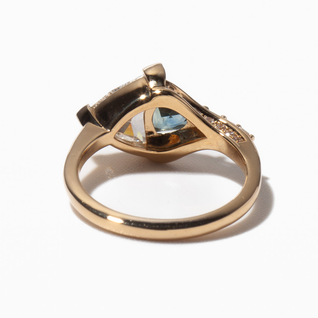 0.85 carat trillion cut lab diamond engagement ring with teal sapphire accents in a minimal contemporary setting