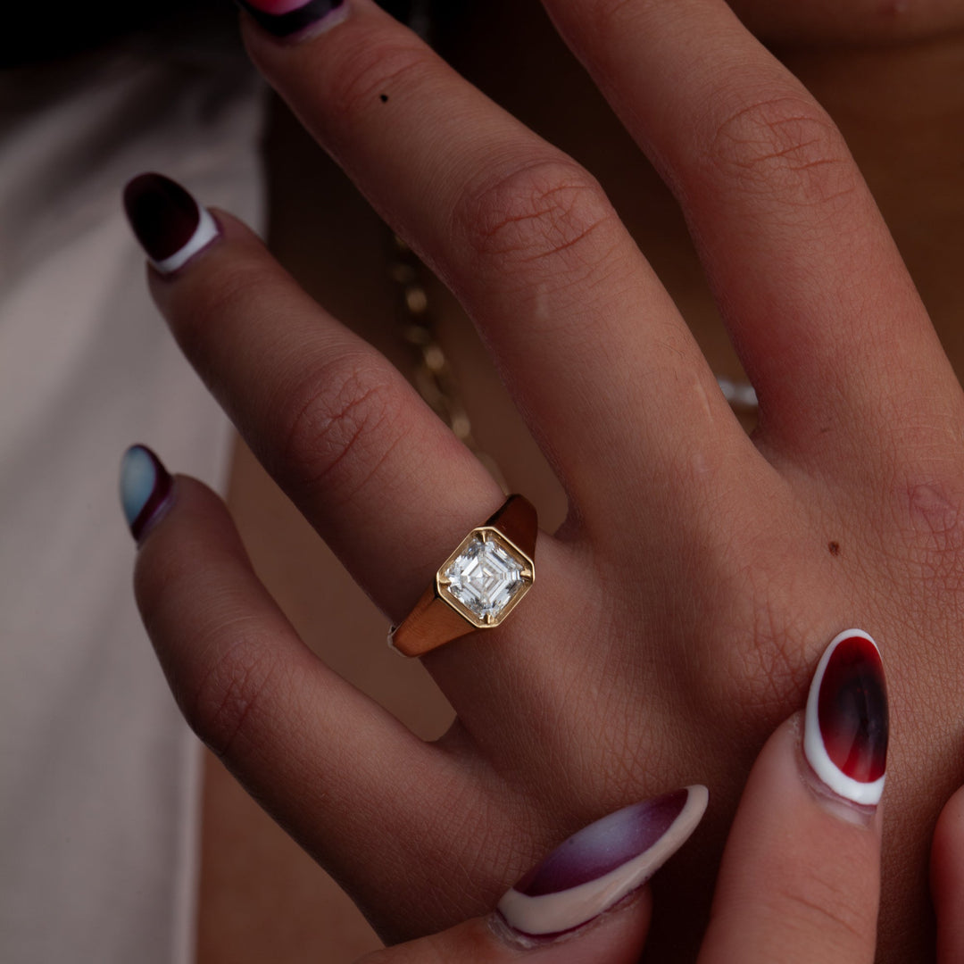 Professional jewelry photography of 1.5 carat Asscher cut lab grown diamond signet engagement ring with sharp sparkle