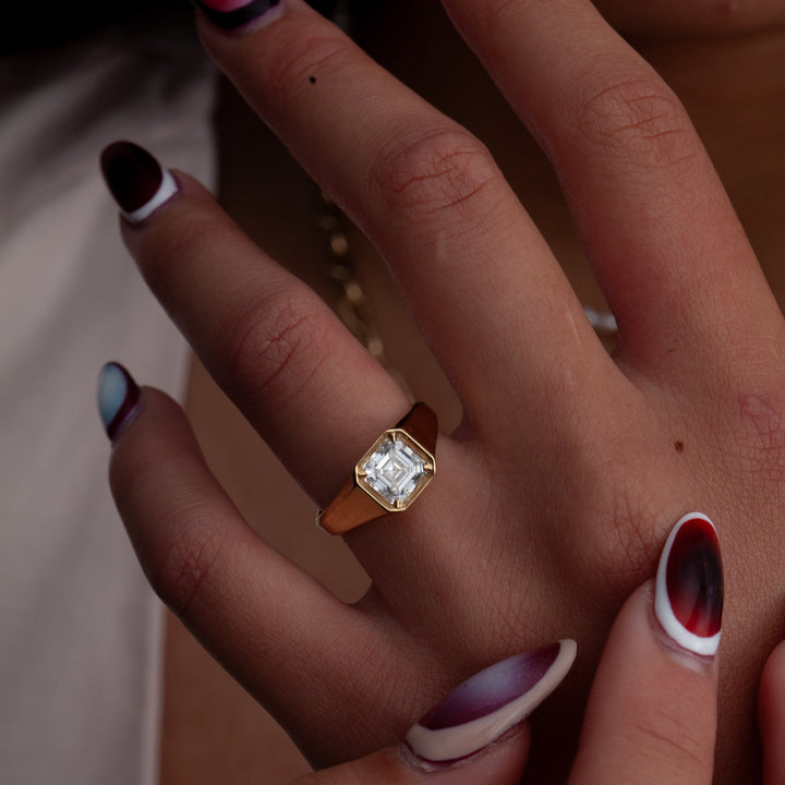 Professional jewelry photography of 1.5 carat Asscher cut lab grown diamond signet engagement ring with sharp sparkle