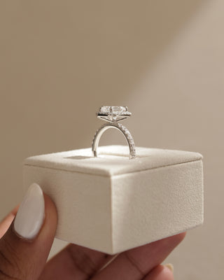 Professional jewelry photography of a 1.50 carat emerald cut lab diamond halo pavé engagement ring in studio lighting