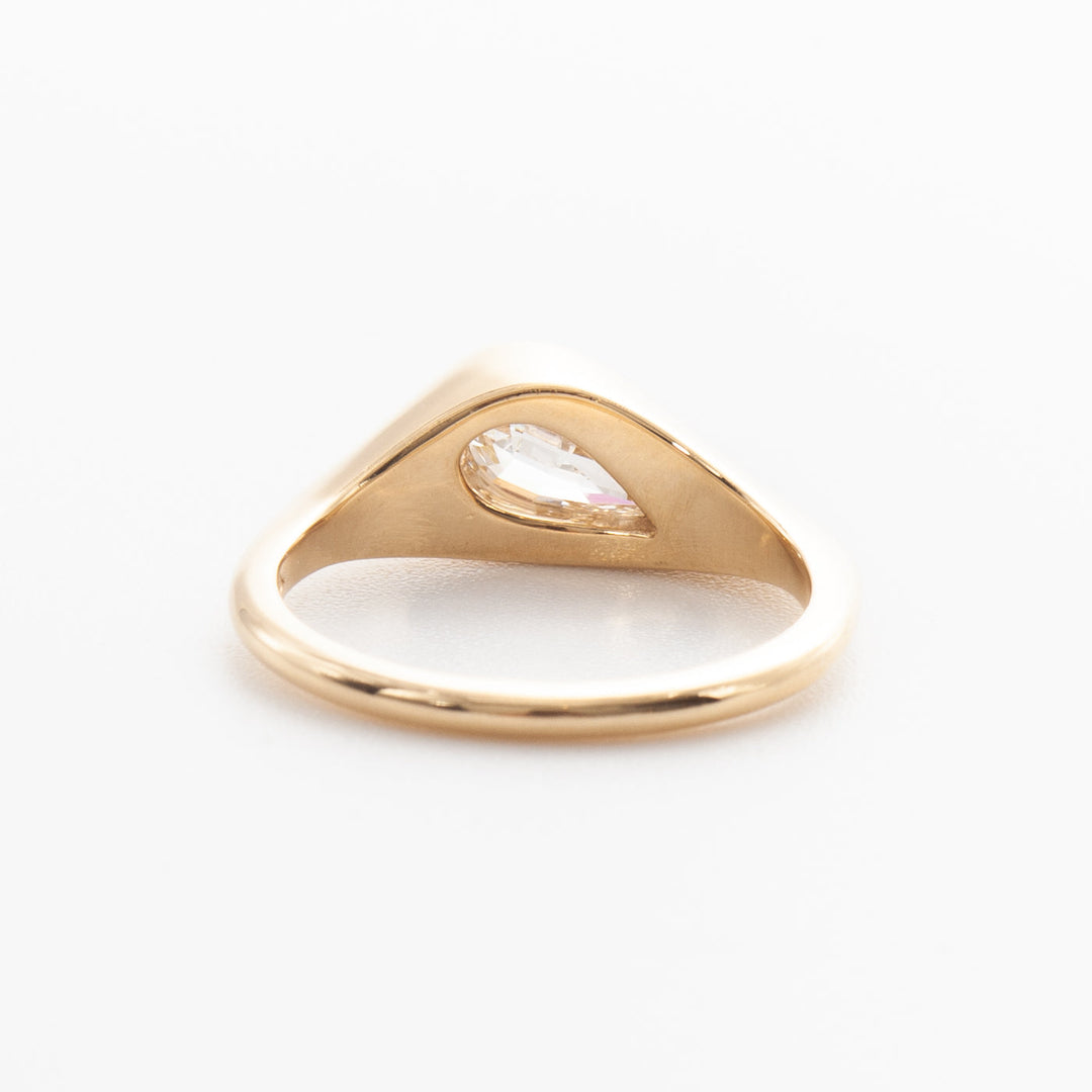 1.5 carat pear cut lab grown diamond bezel engagement ring in minimal gold setting with antique inspired design