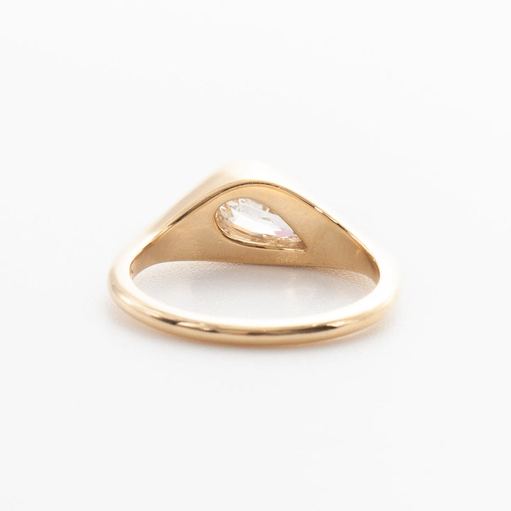 1.5 carat pear cut lab grown diamond bezel engagement ring in minimal gold setting with antique inspired design