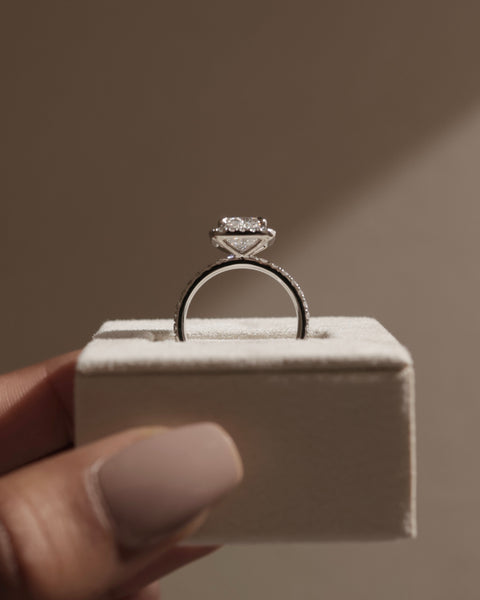 Professional jewelry photography of 1.5 carat radiant E VS2 lab grown diamond halo pavé engagement ring studio lighting