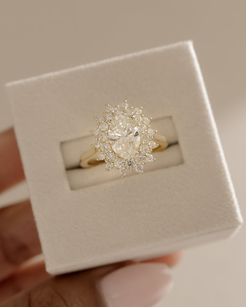 2 carat oval lab grown diamond halo cluster engagement ring set in polished gold modern bridal style