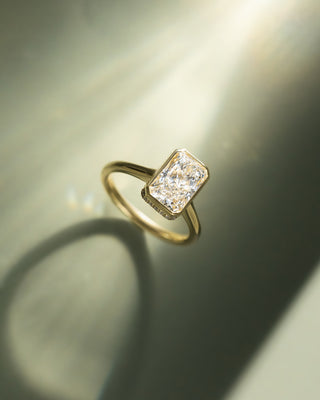 2 carat radiant lab grown diamond bezel hidden halo engagement ring crafted in polished gold with contemporary elegance