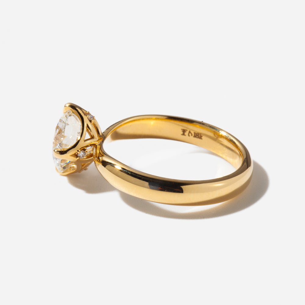 Side profile of a 2 carat round lab diamond solitaire engagement ring with a classic prong setting