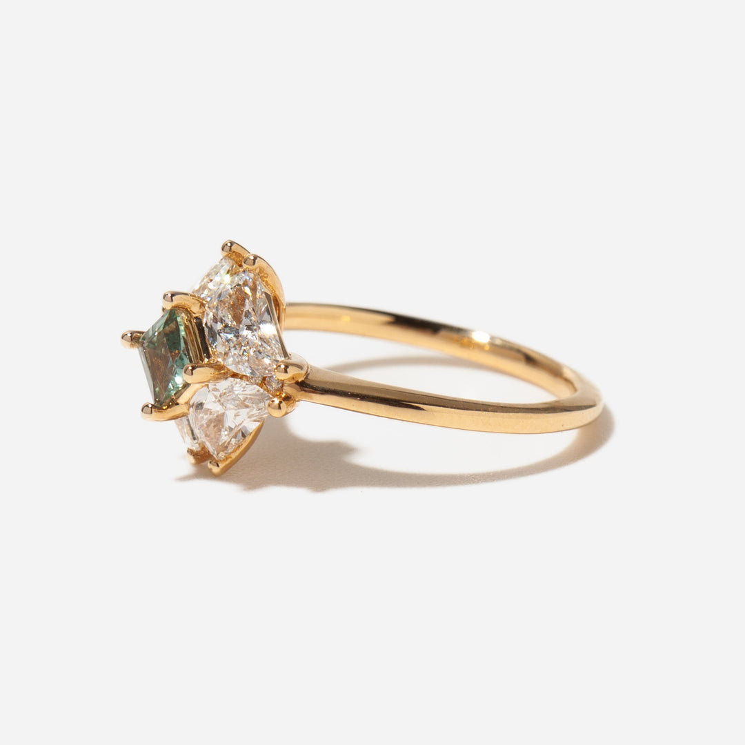 Side profile of teal sapphire half moon lab diamond engagement ring showing modern asymmetric setting structure