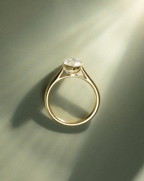 Marquise cut lab diamond engagement ring featuring a cathedral setting and sleek bezel frame around the center stone