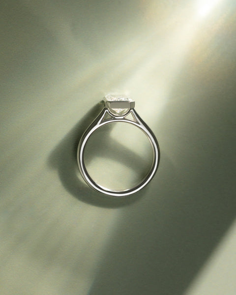 Radiant cut lab diamond engagement ring featuring a cathedral setting and sleek bezel frame around the center stone