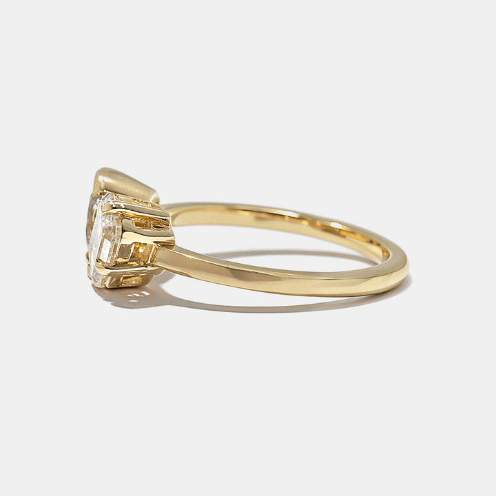 Side profile of round and emerald cut lab grown diamond bezel Toi Et Moi engagement ring with modern dual stone layout