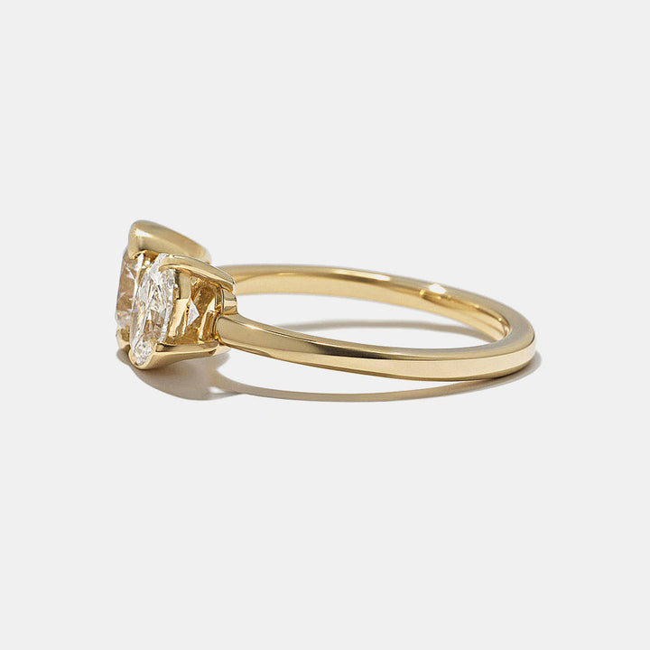 Side profile of round and oval lab grown diamond bezel Toi Et Moi engagement ring with clean modern dual stone layout