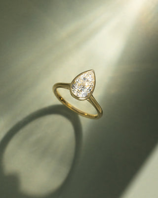 Detailed view of bezel set pear E VS1 lab grown diamond engagement ring showing precision workmanship and refined details