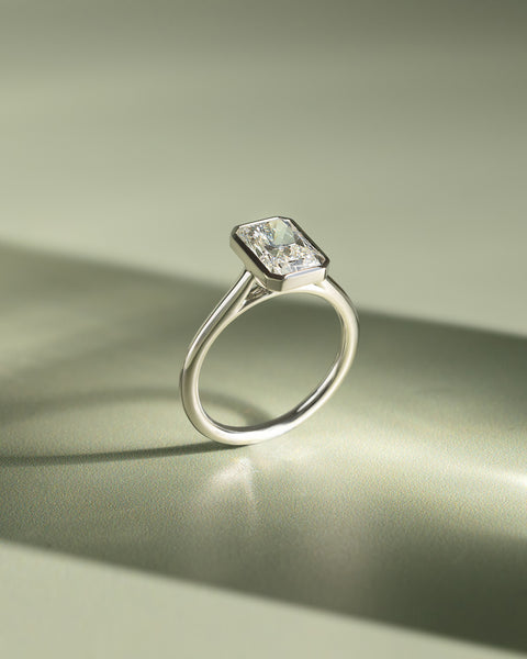 Detailed view of bezel set radiant E VS1 lab grown diamond engagement ring showing precision workmanship and refined details