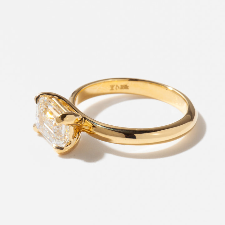 Close-up of east west emerald cut lab grown diamond solitaire ring showing step-cut facets and elongated horizontal design