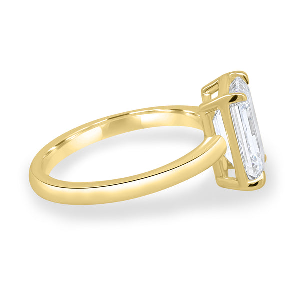 Side profile of bezel set emerald lab grown diamond solitaire engagement ring showing sleek structure and elevated center stone