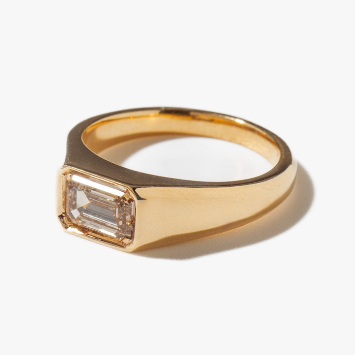 Side profile of horizontal emerald cut lab diamond signet engagement ring with sleek architectural setting design