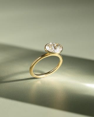 East west oval lab diamond engagement ring featuring a bezel setting and clean modern bridal aesthetic