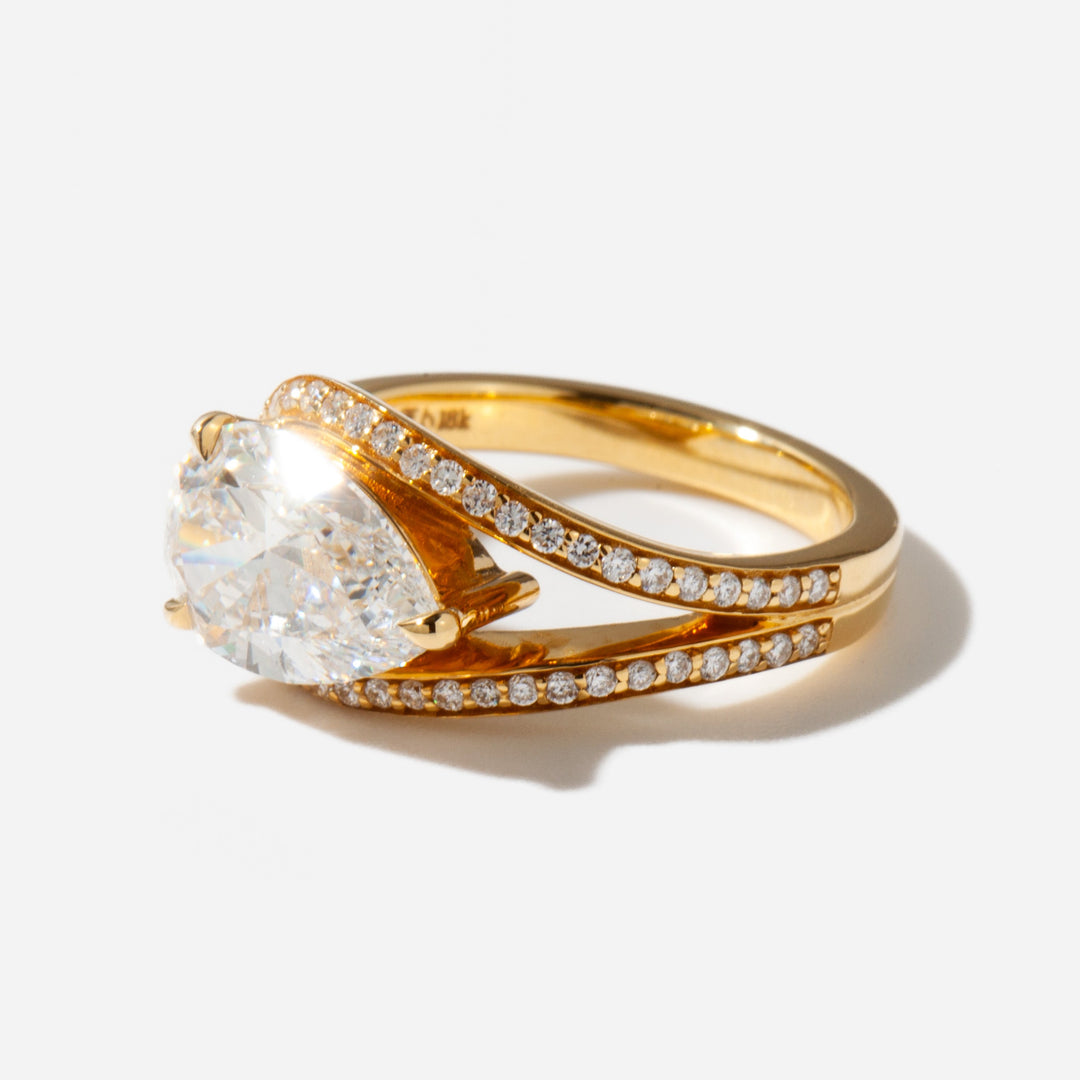 Close-up of an east west pear cut lab grown diamond engagement ring highlighting unique horizontal orientation and brilliance