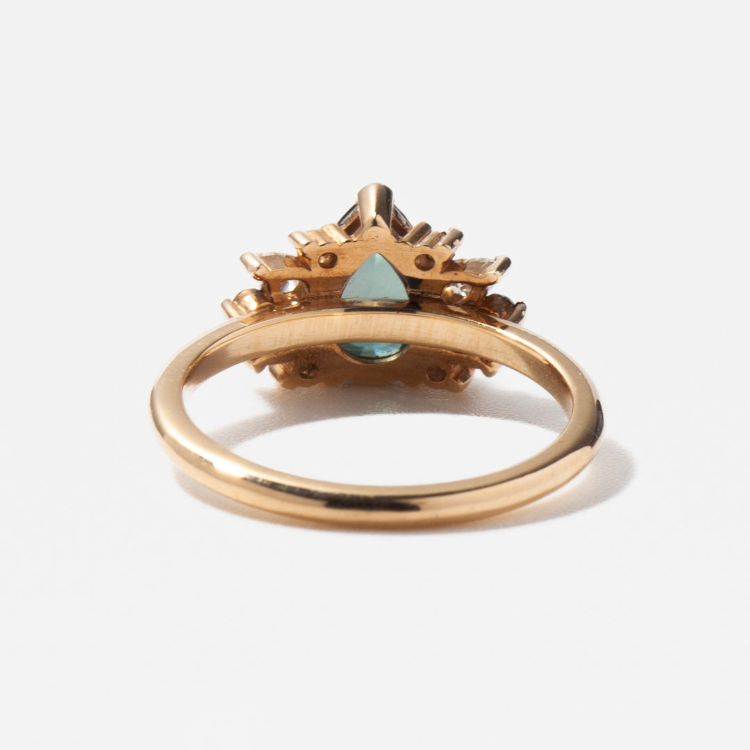 Modern cluster engagement ring featuring pear sapphire center stone with lab grown diamond halo arrangement and refined styling