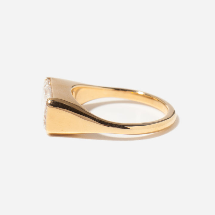 Modern signet style engagement ring featuring east west emerald cut lab grown diamond in bold solitaire setting