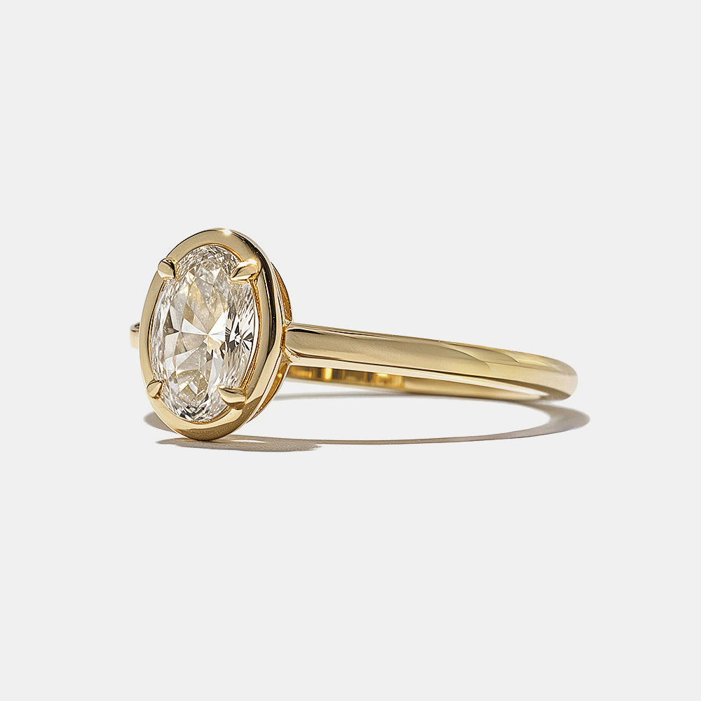 Close-up of oval lab grown diamond bezel engagement ring showing sleek metal frame and elegant elongated shape