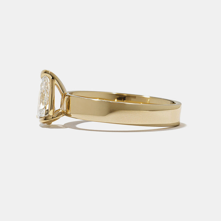Close-up of pear lab grown diamond cigar band engagement ring showing elongated shape and wide modern band setting