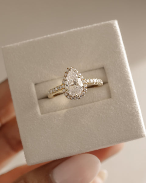Detailed view of pear E VS2 lab grown diamond halo pavé engagement ring showing clarity and pavé sparkle