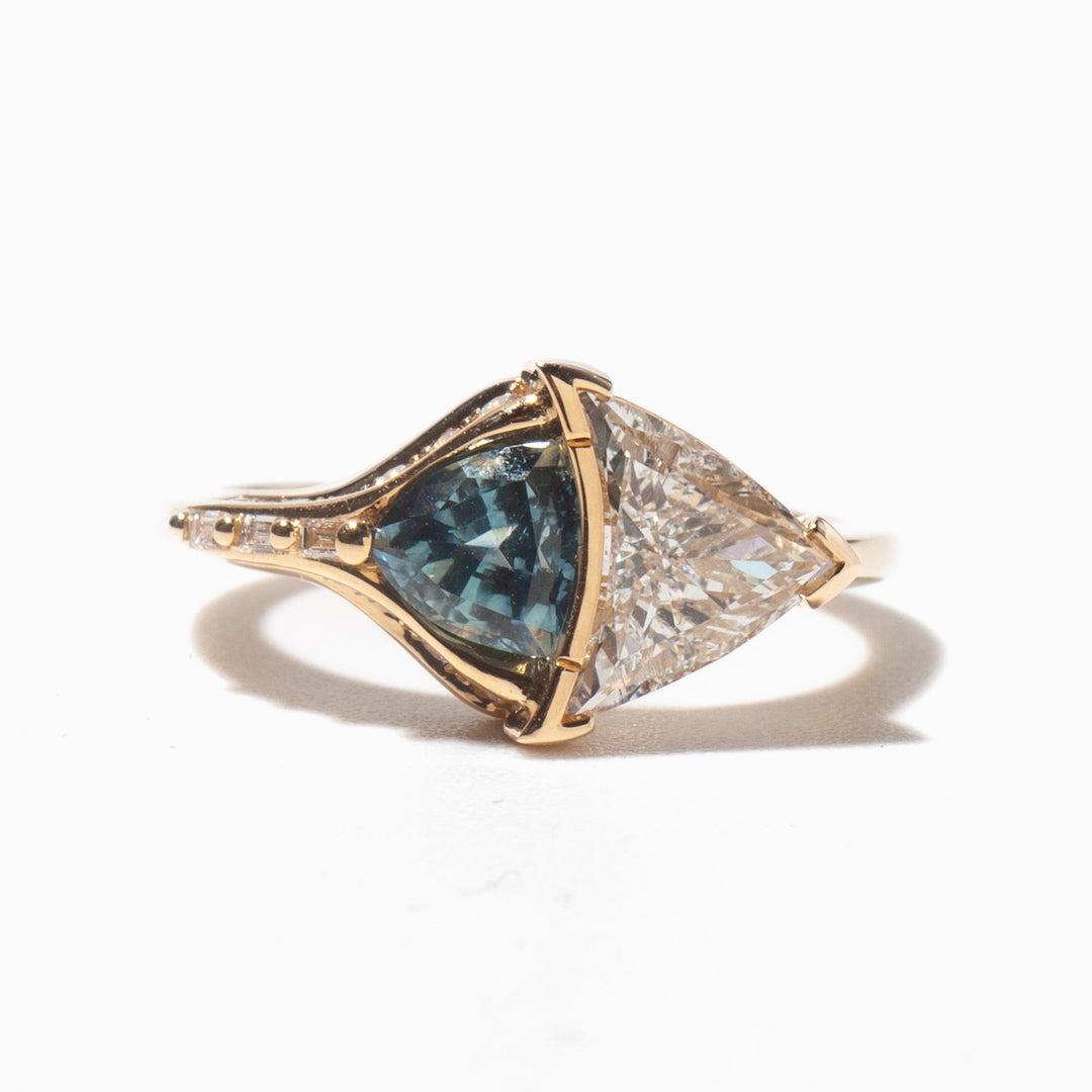 Detailed view of trillion cut lab diamond engagement ring with teal sapphire accents highlighting aquatic inspired design