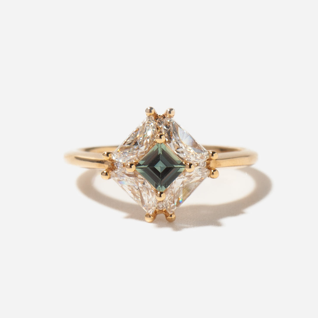 Front view of teal sapphire and half moon lab grown diamond engagement ring featuring asymmetric modern gemstone layout