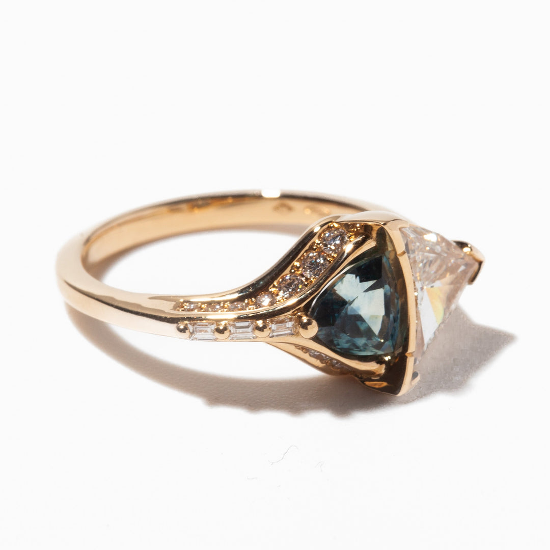 Unique engagement ring featuring trillion cut lab diamond paired with teal sapphire for modern alternative bridal style