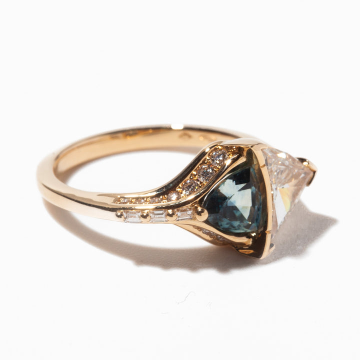 Unique engagement ring featuring trillion cut lab diamond paired with teal sapphire for modern alternative bridal style